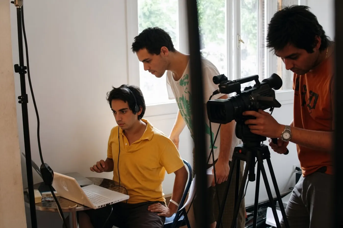 Polo con auriculares frente a un Mac, cámara profesional y equipo de Cuul.tv